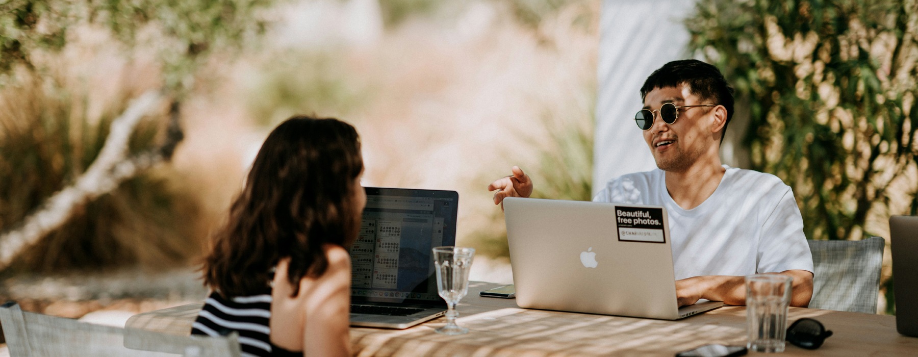 man and woman sitting at a table with laptops